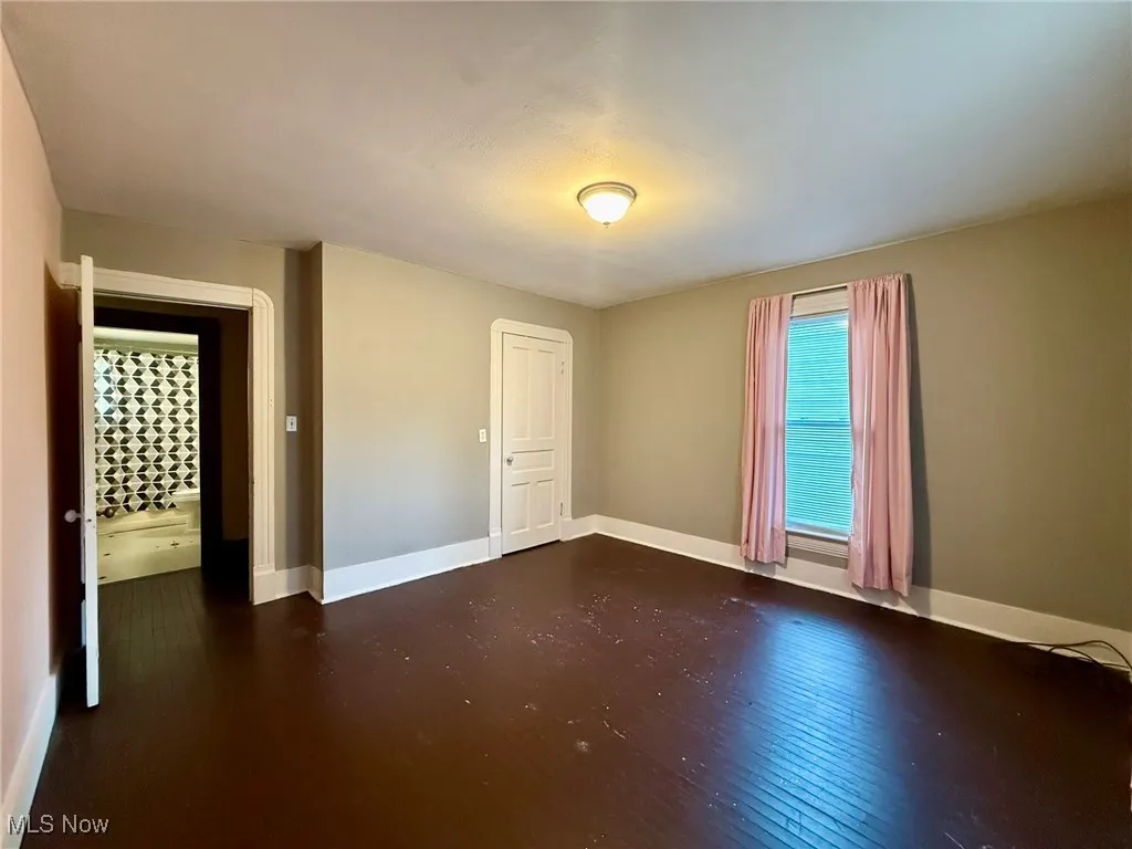 Bedroom with hardwood / wood-style flooring and baseboards