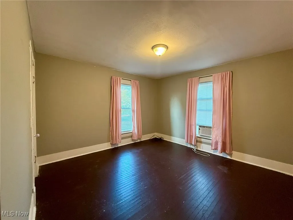 Bedroom with hardwood / wood-style flooring and baseboards