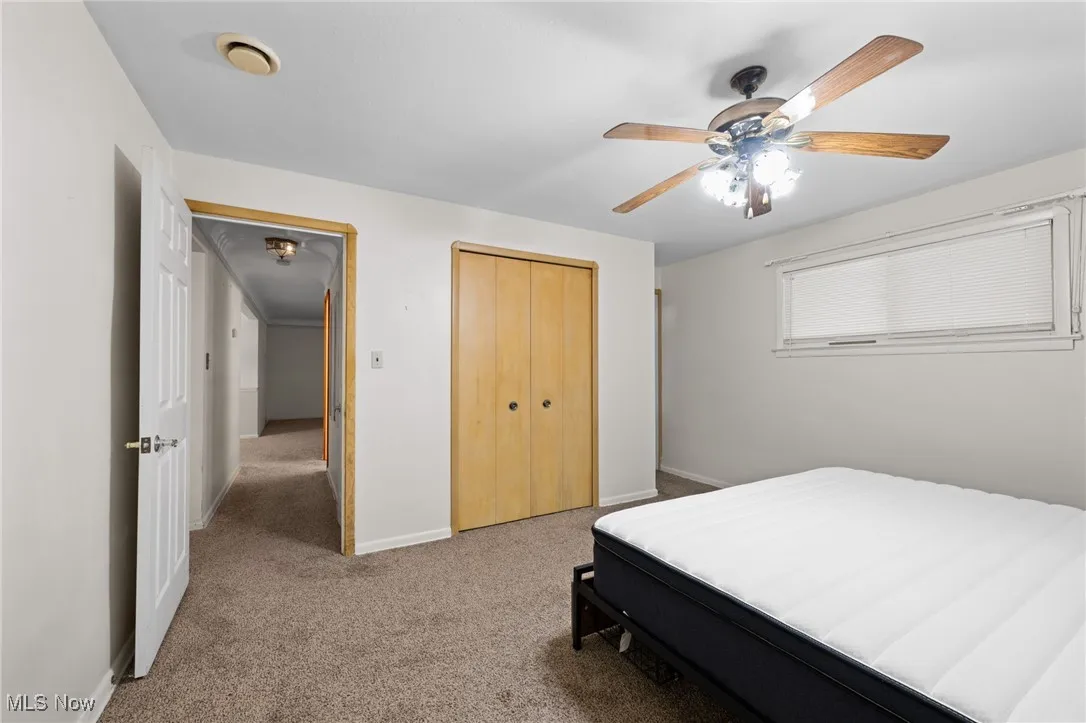 Bedroom with carpet floors, a ceiling fan, and a closet