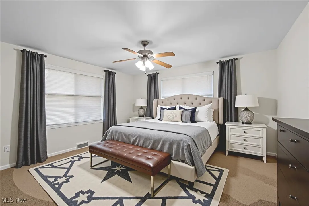Bedroom with light carpet and a ceiling fan
