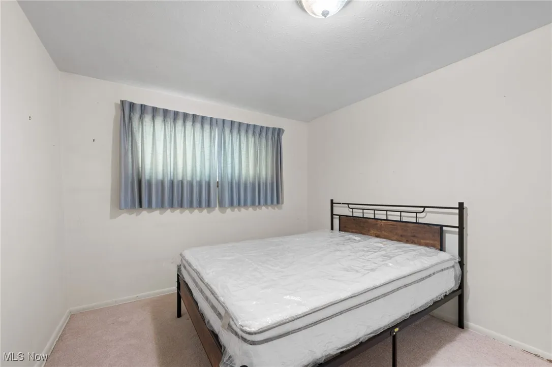 Bedroom featuring light carpet