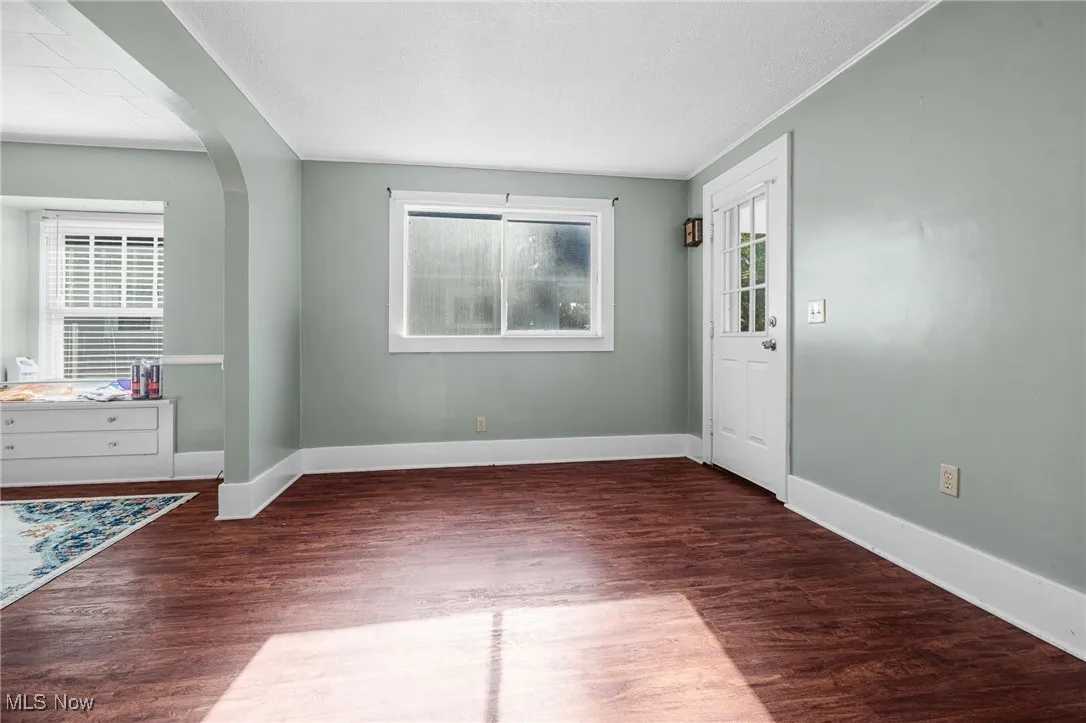 Entryway featuring arched walkways and dark wood-type flooring