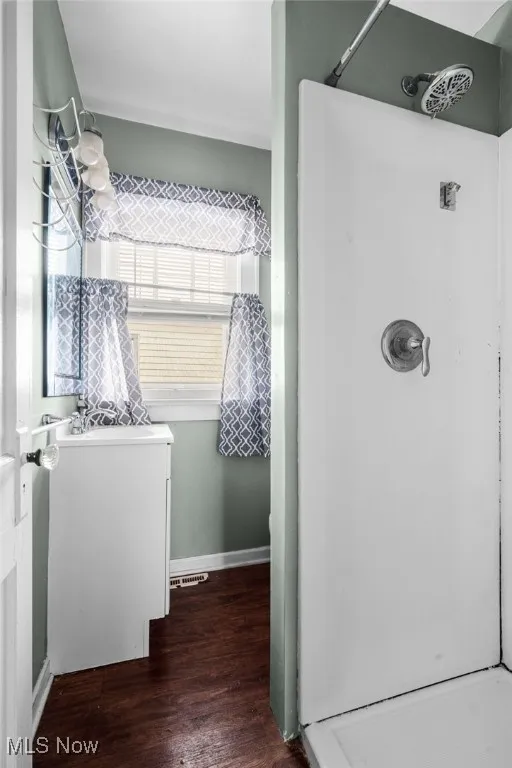 Bathroom featuring dark wood finished floors and a shower