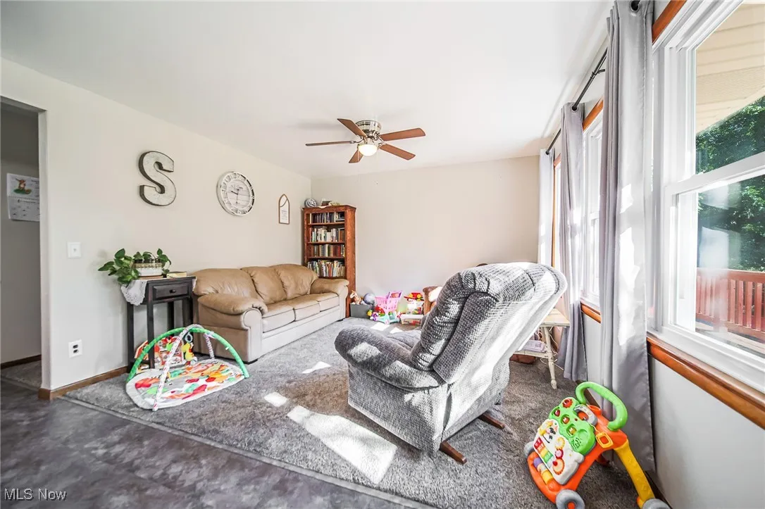 Living room featuring a ceiling fan and baseboards
