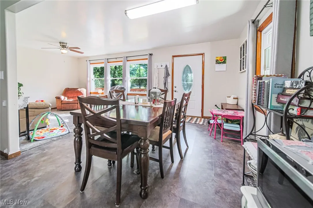 Dining room featuring a ceiling fan and concrete floors
