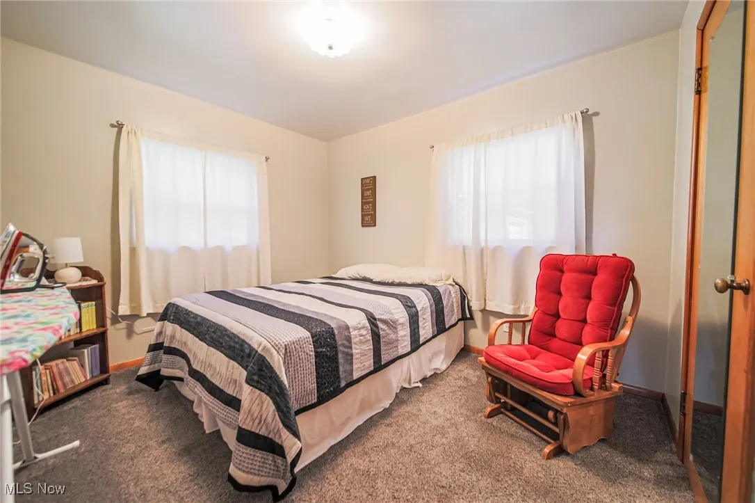 Bedroom featuring dark carpet and baseboards