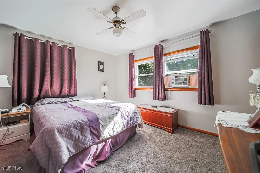 Bedroom with carpet flooring, ceiling fan, and cooling unit