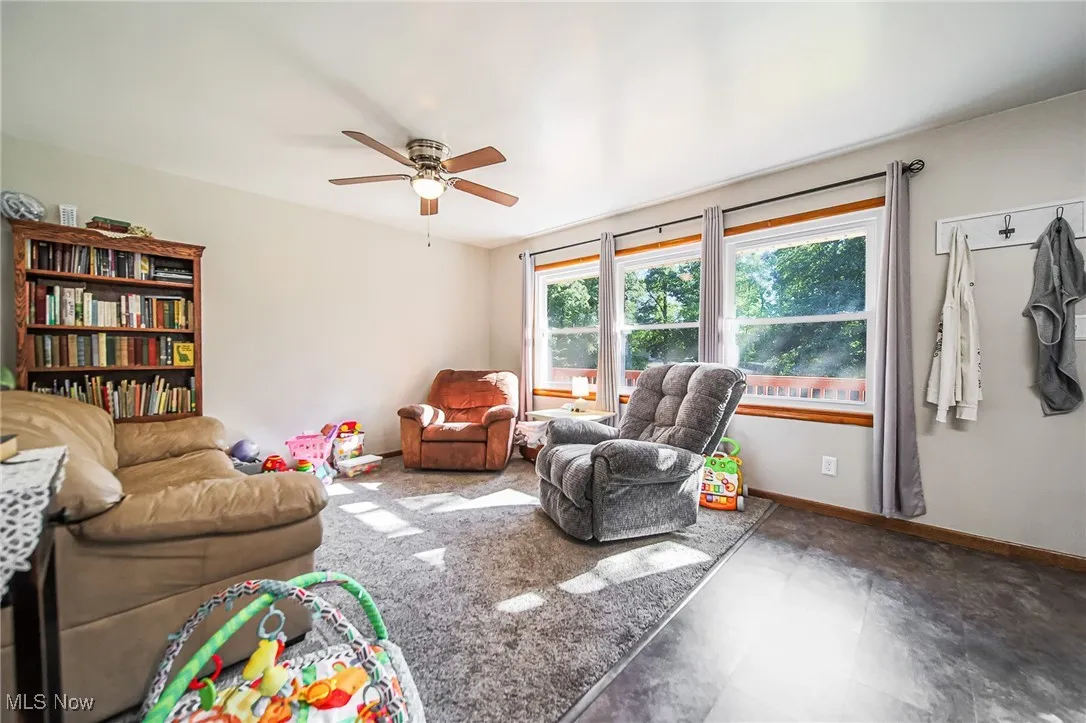 Living area with baseboards and a ceiling fan