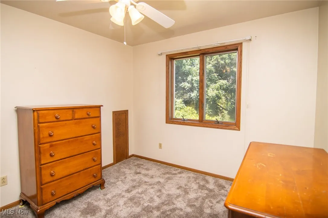 Bedroom with light carpet and a ceiling fan