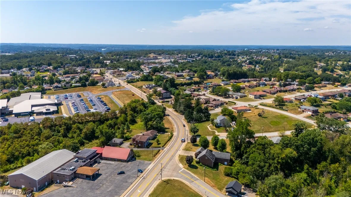 Aerial view of property's location with a tree filled landscape
