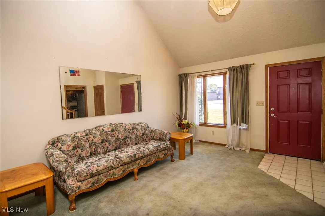 Entryway featuring carpet and high vaulted ceiling