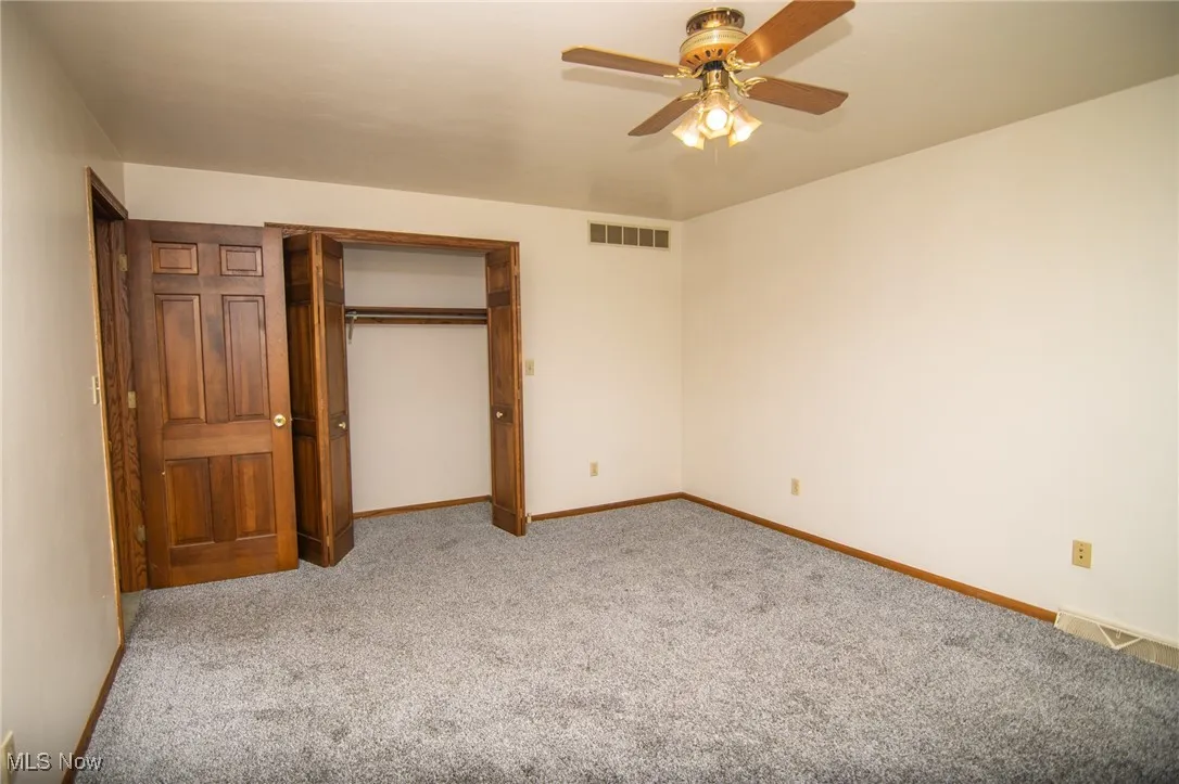 Unfurnished bedroom with carpet floors, a closet, and a ceiling fan