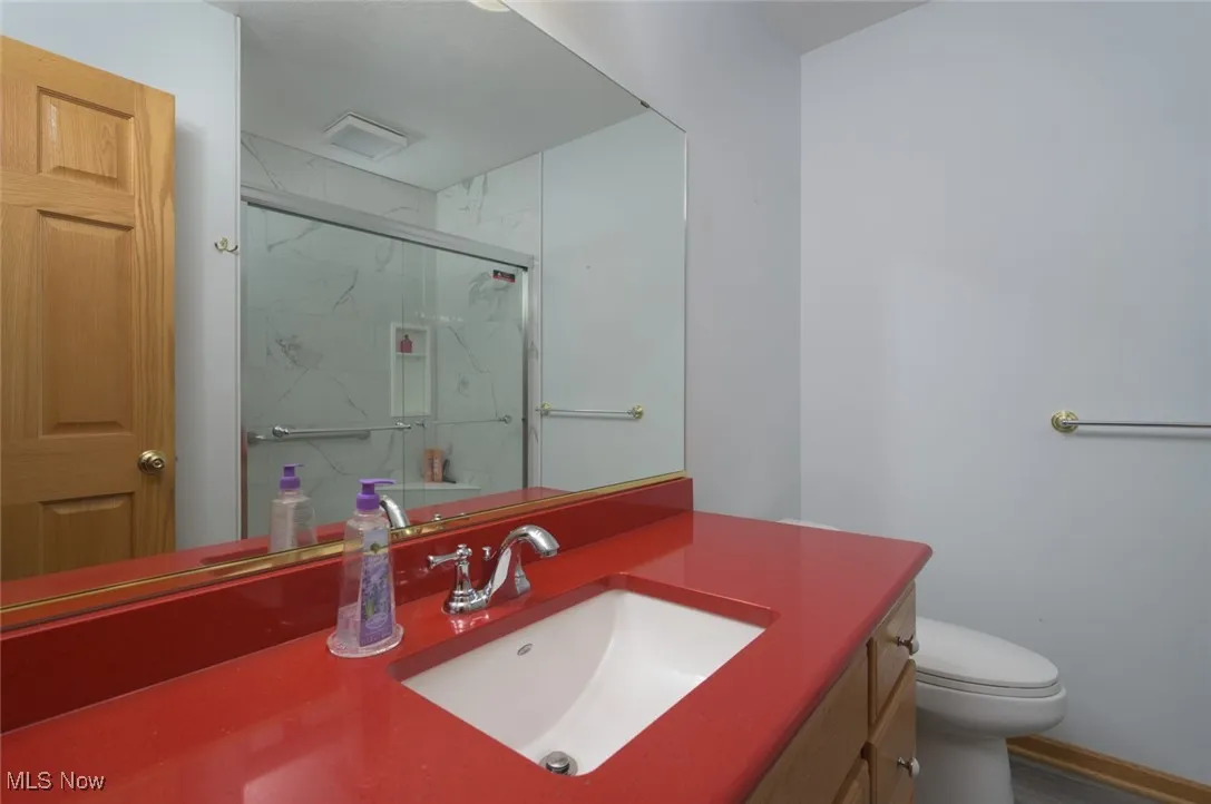 Full bathroom featuring vanity and a marble finish shower