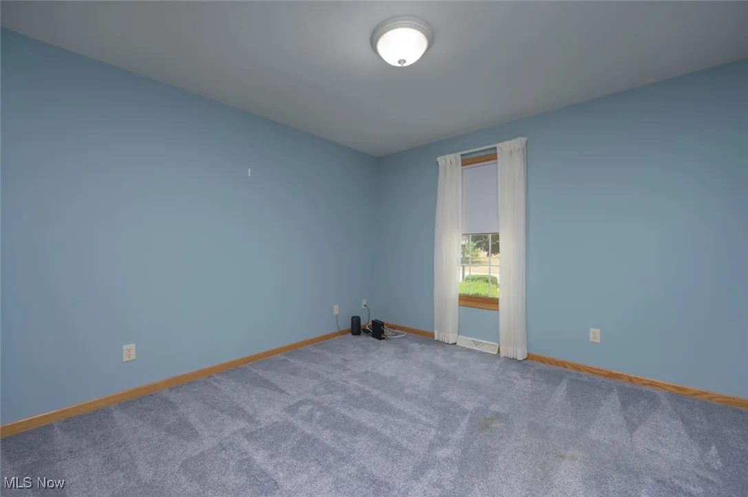 Unfurnished room featuring baseboards and carpet floors
