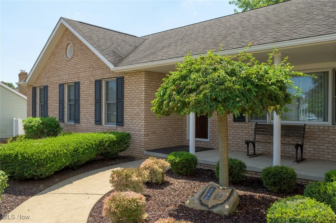 Property entrance featuring brick siding and roof with shingles