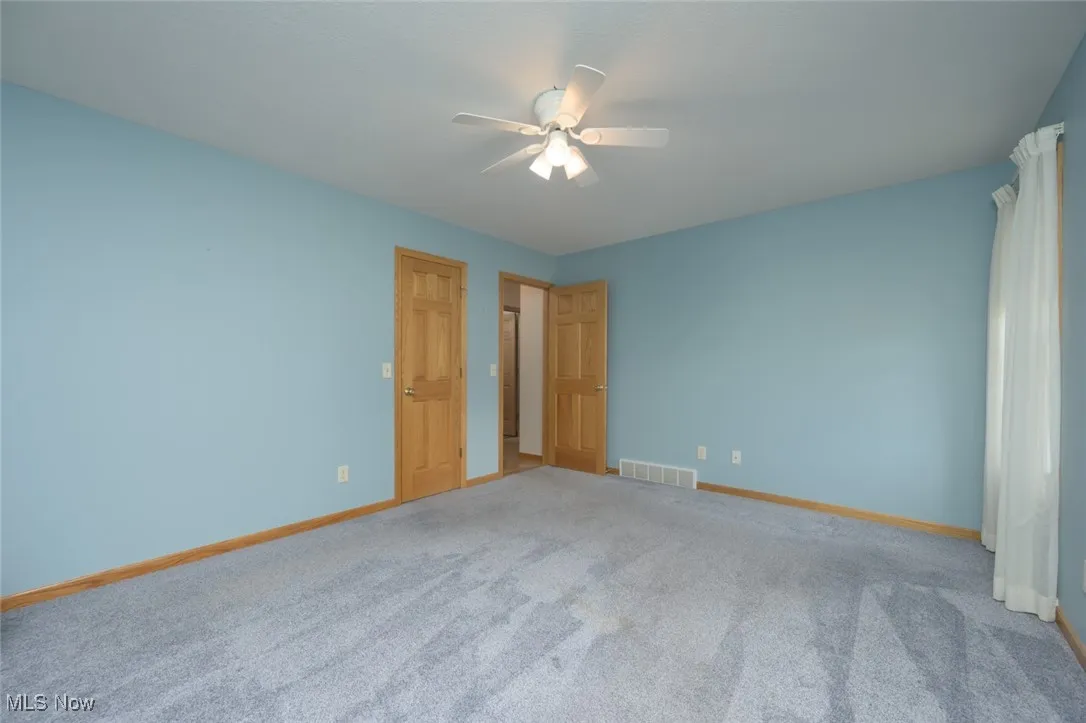 Unfurnished bedroom with ceiling fan and carpet floors