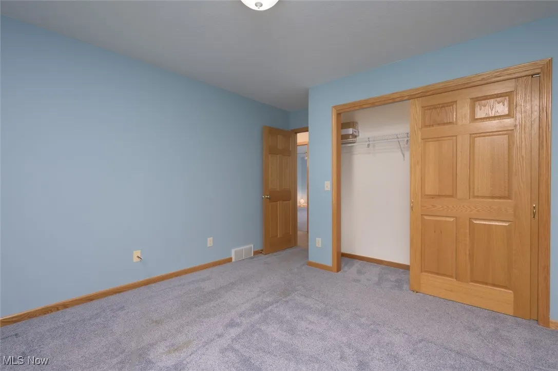 Unfurnished bedroom with a closet and carpet