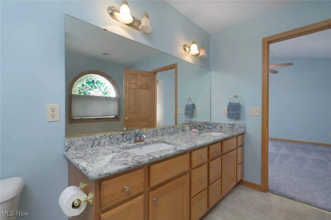 Full bathroom featuring double vanity and baseboards