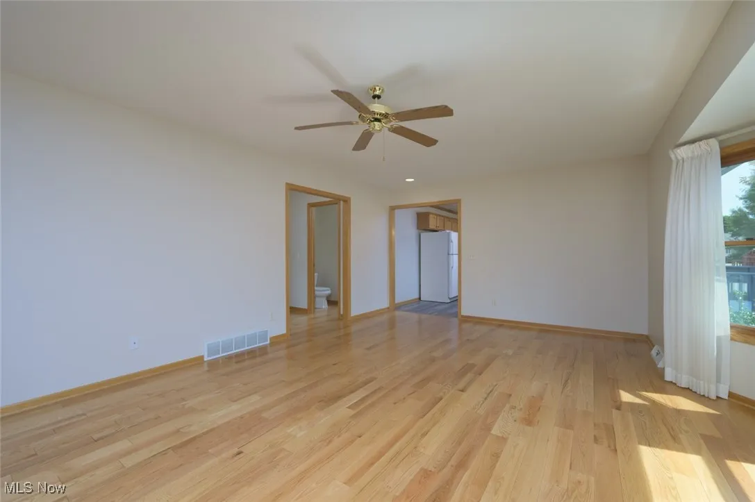 Empty room featuring light wood-style flooring and ceiling fan