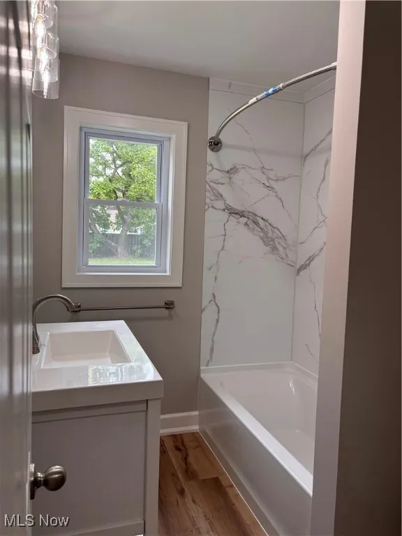 Full bathroom with shower / washtub combination, vanity, and light wood-type flooring