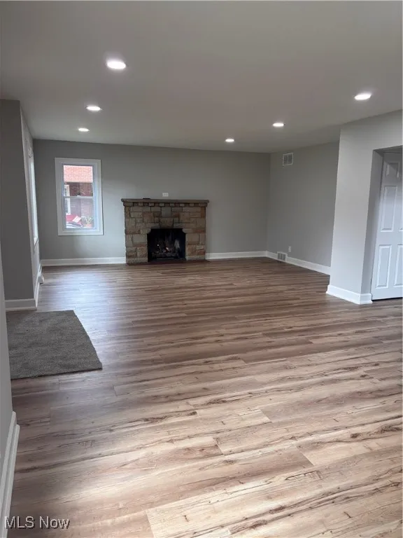 Unfurnished living room featuring recessed lighting, a fireplace, and light wood-style flooring