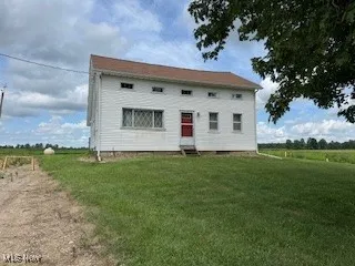 Back of house featuring a lawn