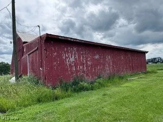 View of pole building featuring a lawn