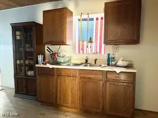 Kitchen featuring light countertops, light wood finished floors, and brown cabinets