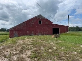 View of barn featuring a yard