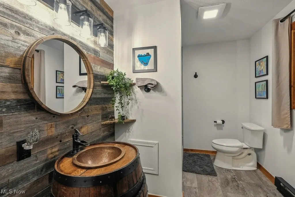 Bathroom with light wood finished floors and wooden walls