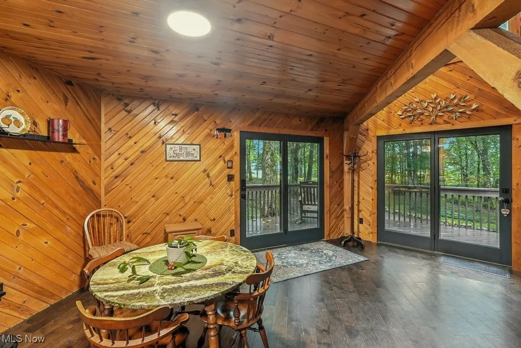 Dining area with wood walls, wood finished floors, wooden ceiling, and vaulted ceiling