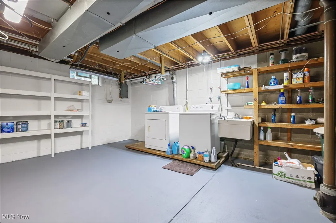 Basement with washer and clothes dryer and electric panel