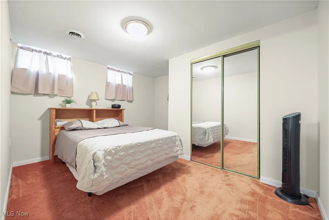 Carpeted bedroom featuring a closet and baseboards