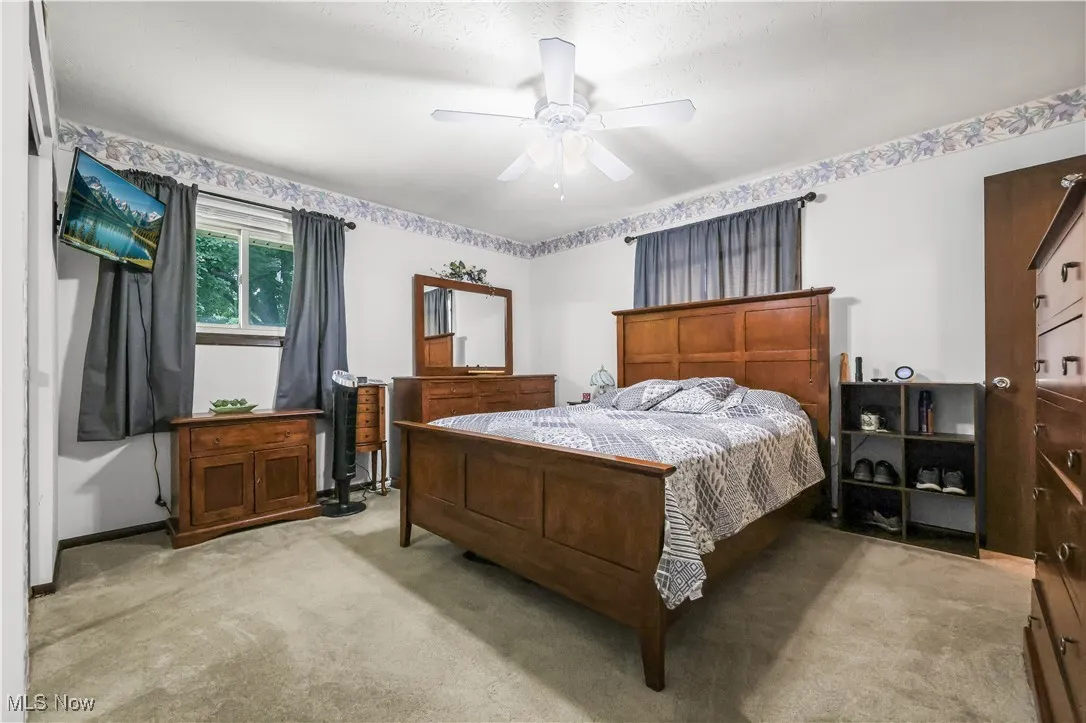 Bedroom featuring light carpet and a ceiling fan