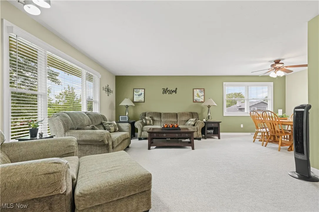 Living area with carpet floors and a ceiling fan