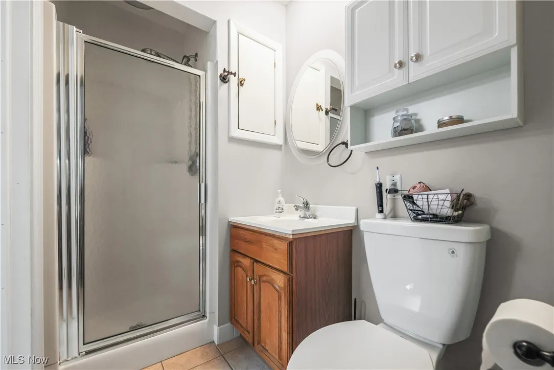 Bathroom with a stall shower, vanity, and light tile patterned floors