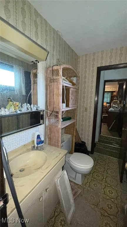 Bathroom featuring vanity and wallpapered walls
