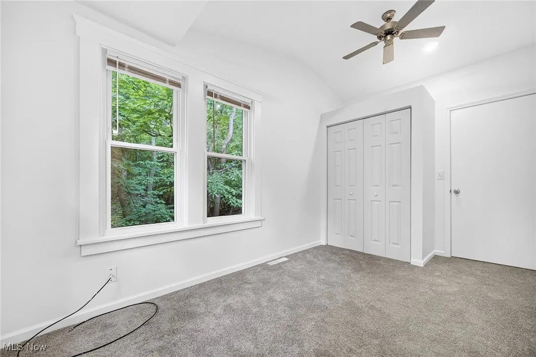 Unfurnished bedroom with vaulted ceiling, carpet flooring, ceiling fan, and a closet