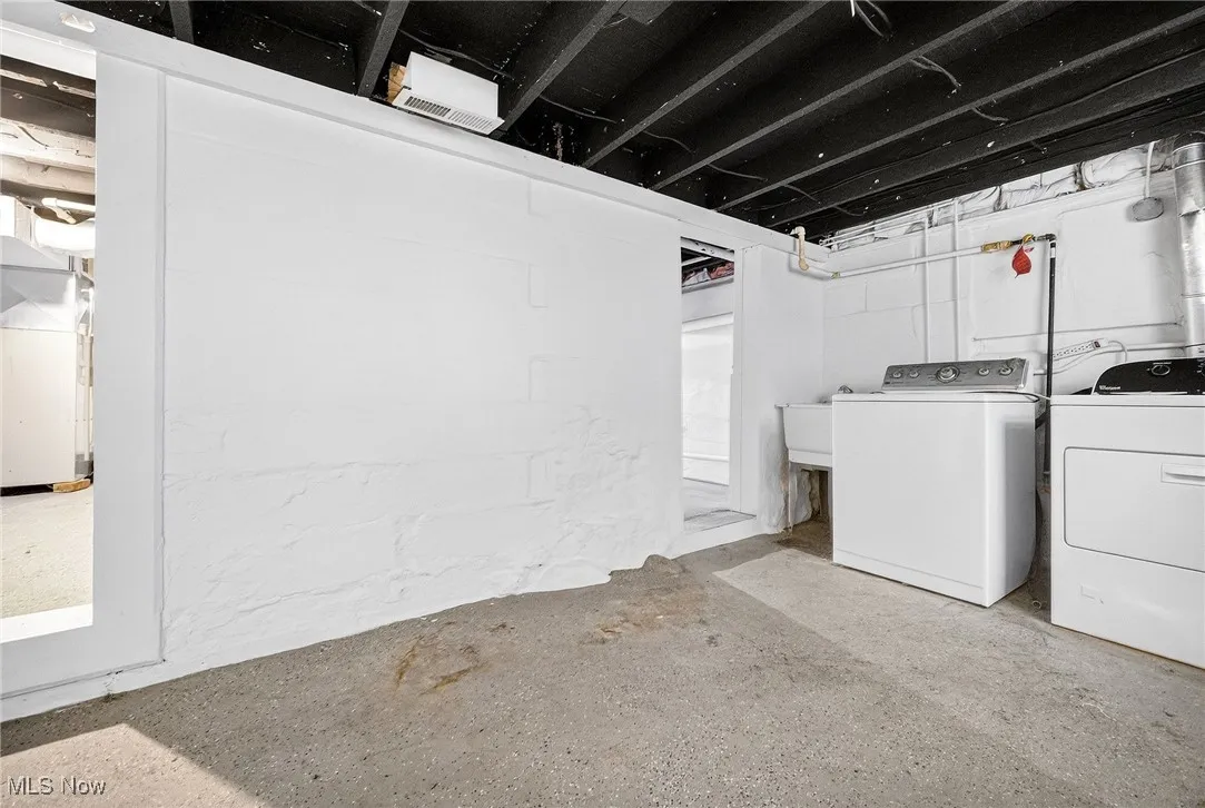 Unfinished below grade area with washing machine and dryer and heating unit