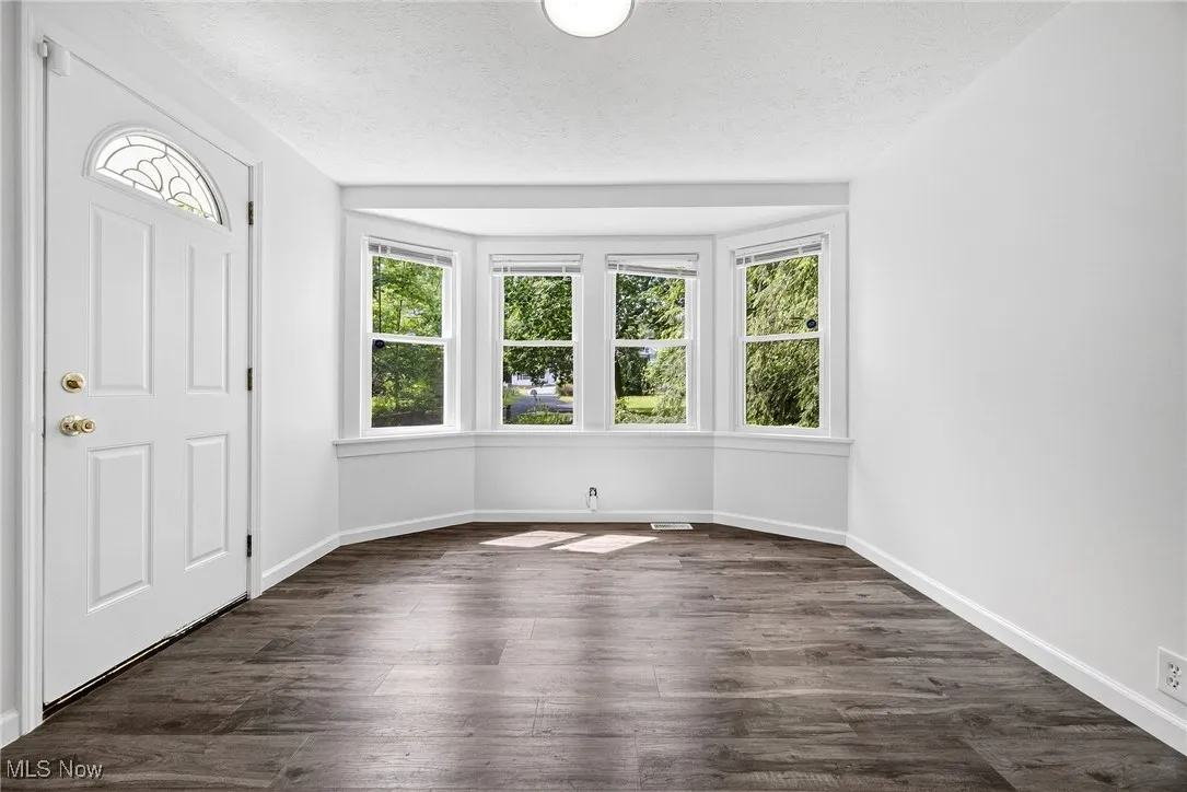 Foyer with dark wood-style flooring and a textured ceiling