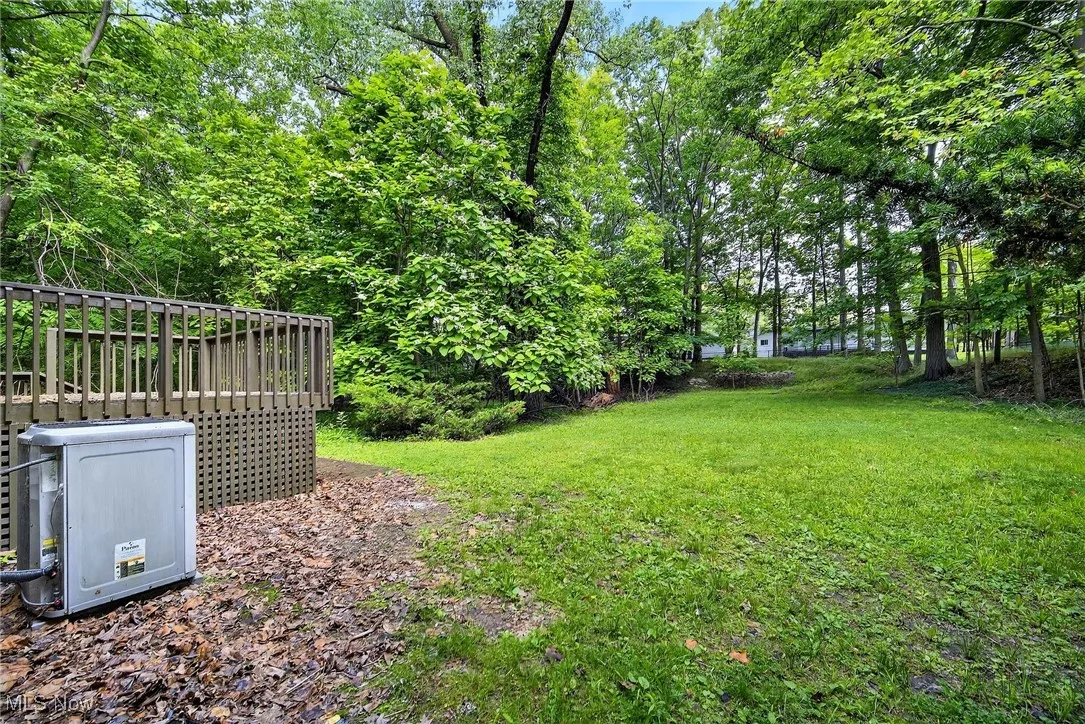 View of green lawn featuring view of scattered trees