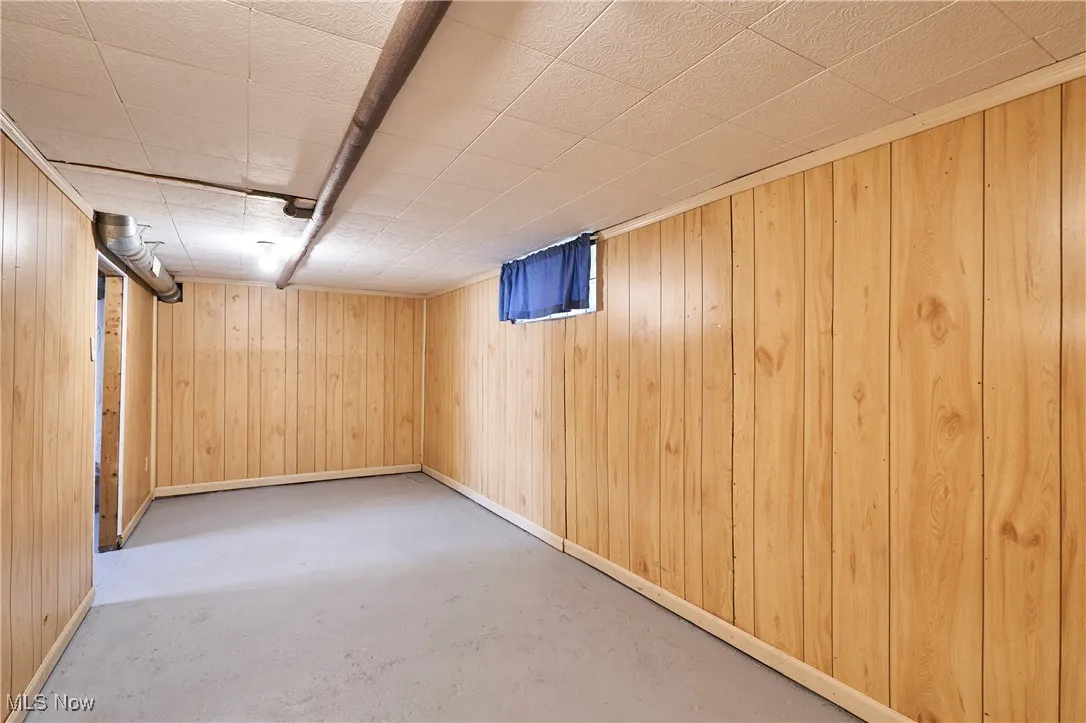 Finished below grade area featuring wood walls and baseboards