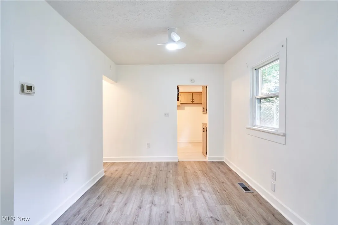 Dining off the Living room with new LVT flooring and neutral decor'