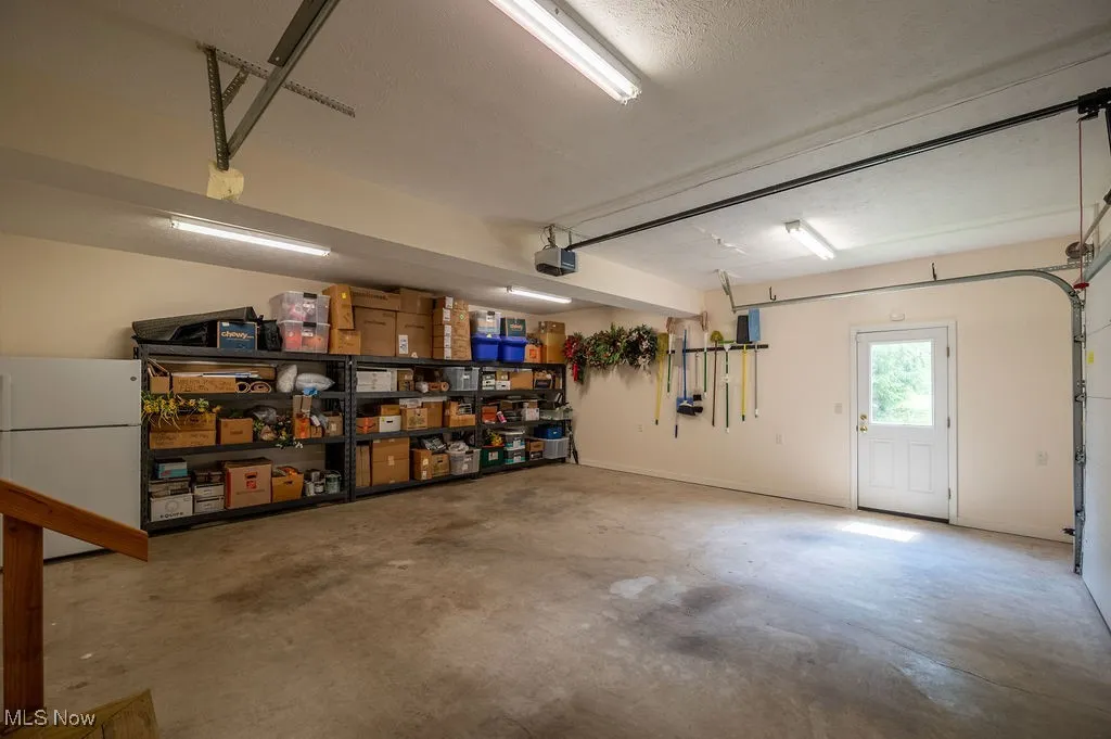 Garage with freestanding refrigerator and a garage door opener