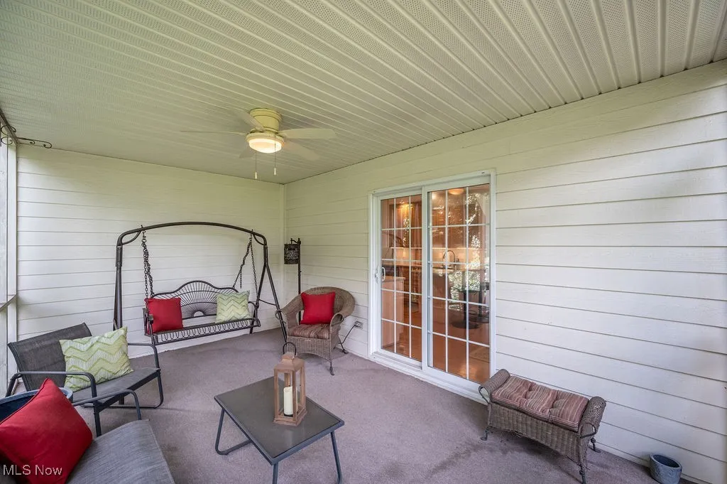 Sunroom / solarium with ceiling fan and a patio area