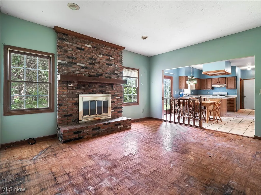 Living area with a brick fireplace and a textured ceiling