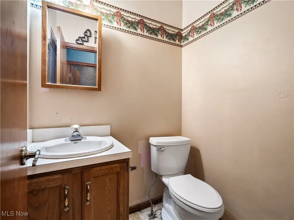 1ar floor half bathroom featuring vanity and toilet