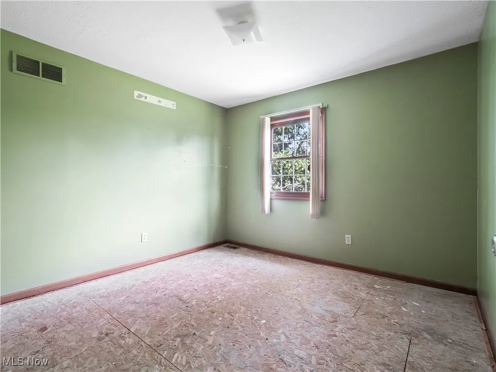 Spare room featuring baseboards