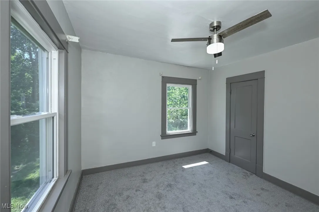 Empty room with carpet and a ceiling fan