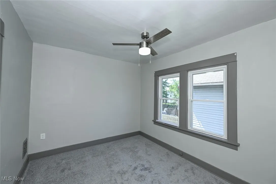 Spare room featuring carpet and a ceiling fan